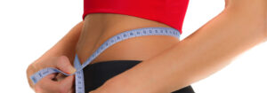 close up of woman measuring her waist with soft measuring tape