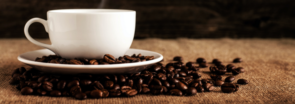 cup of coffee with coffee beans surrounding it