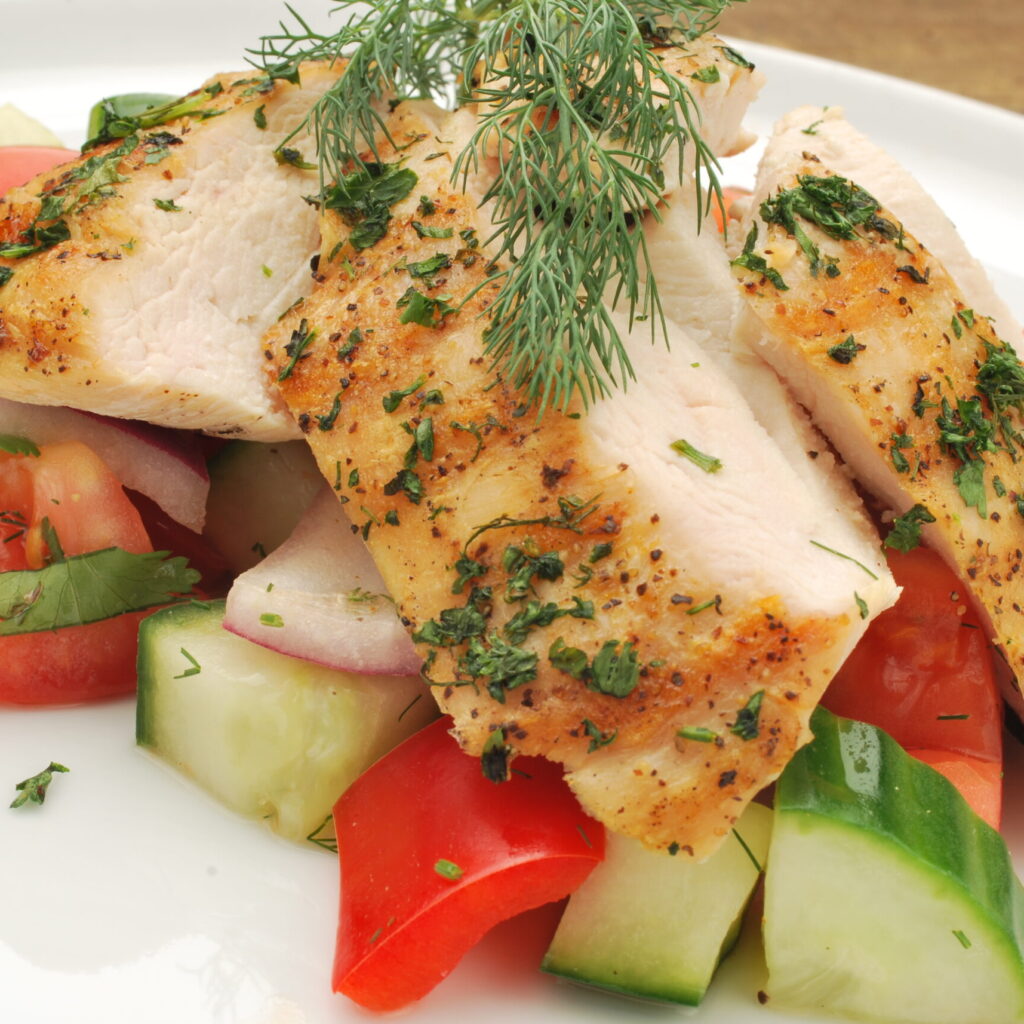 close up of herb chicken with greek vegetables on a plate