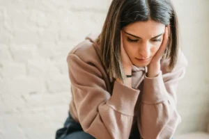 woman hunched over looking unwell