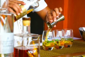 bartender pouring liquor into cocktails