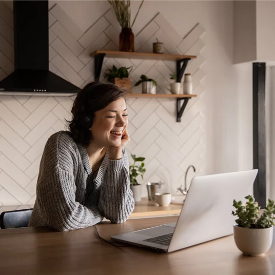 Woman smiling while talking to someone virtually on her computer